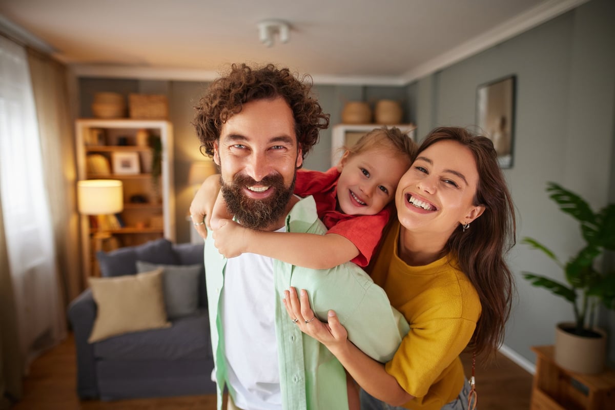 Family of three laughing and hugging, enjoying time together